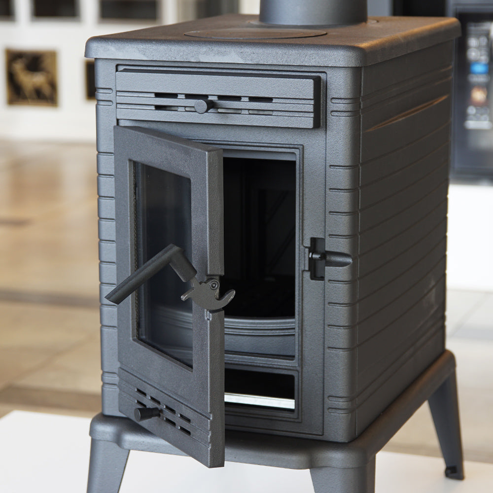 Kratki K10 houtkachel met open deur in een showroom