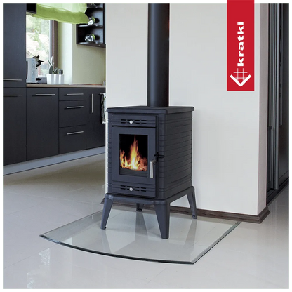 Kratki K10 houtkachel in moderne keuken, geplaatst op glazen plaat, met brandend vuur.