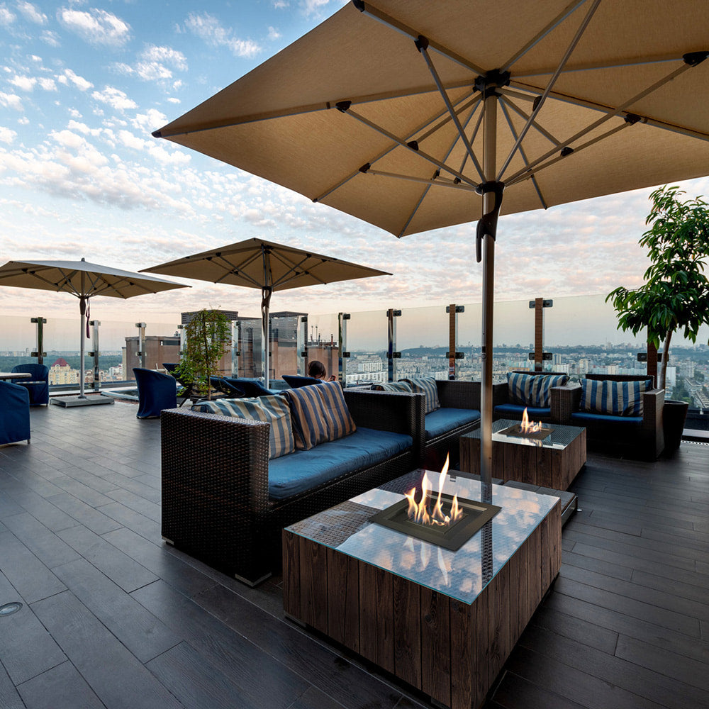 Kratki AQF Vuurtafel op een dakterras met loungesets en parasols