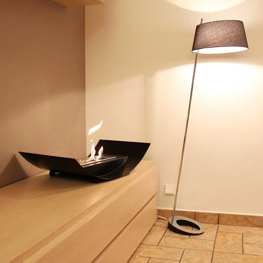 Kratki Biomisa TÜV op houten kast naast moderne vloerlamp in een gezellige kamer.