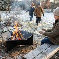 Kratki Gamma vuurschaal met brandend hout in besneeuwde tuin