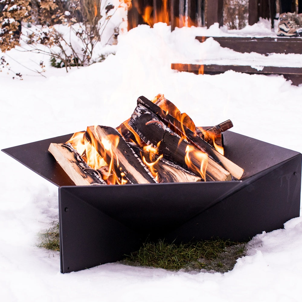 Kratki Gamma vuurkorf in de sneeuw met brandend hout