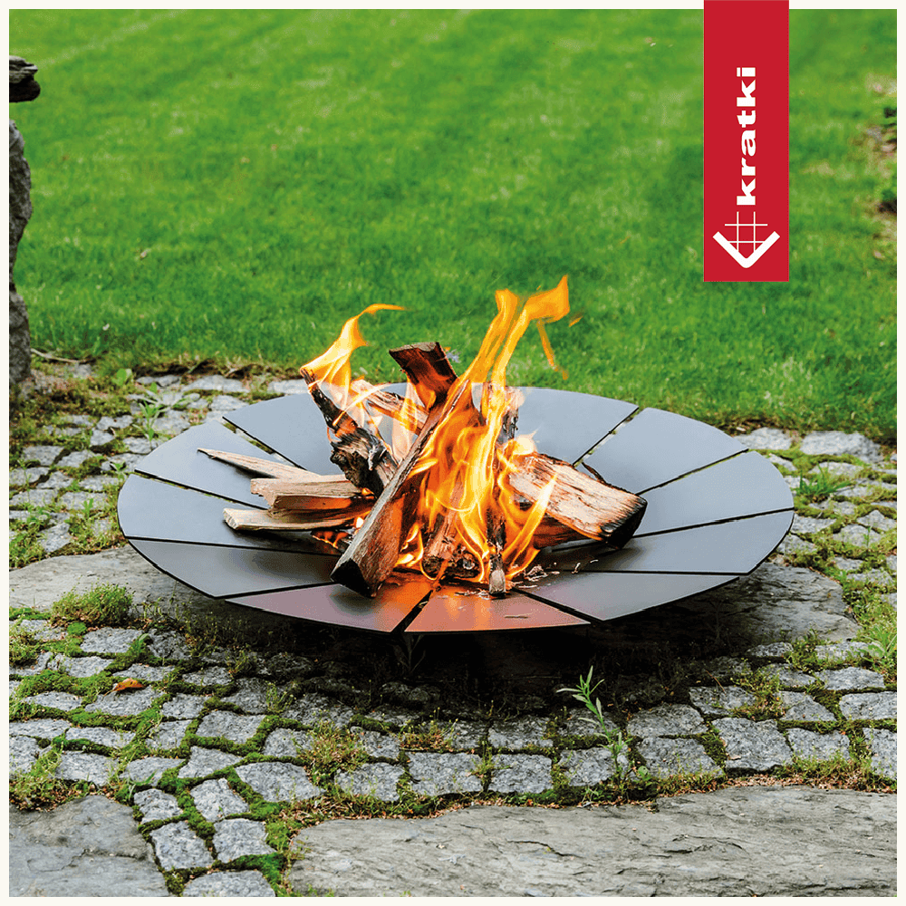 Kratki Sunny vuurkorf met brandend hout op bestrating in de tuin