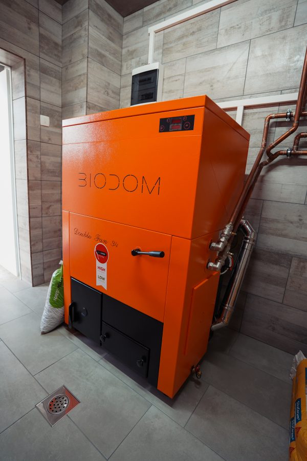 Biodom 27-C5 oranje ketel in technische ruimte met leidingen
