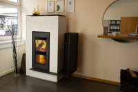 Xeoos Magna x8 houtkachel in showroom met brandend vuur