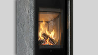 Balstil Akna haard met brandend hout achter een glazen deur
