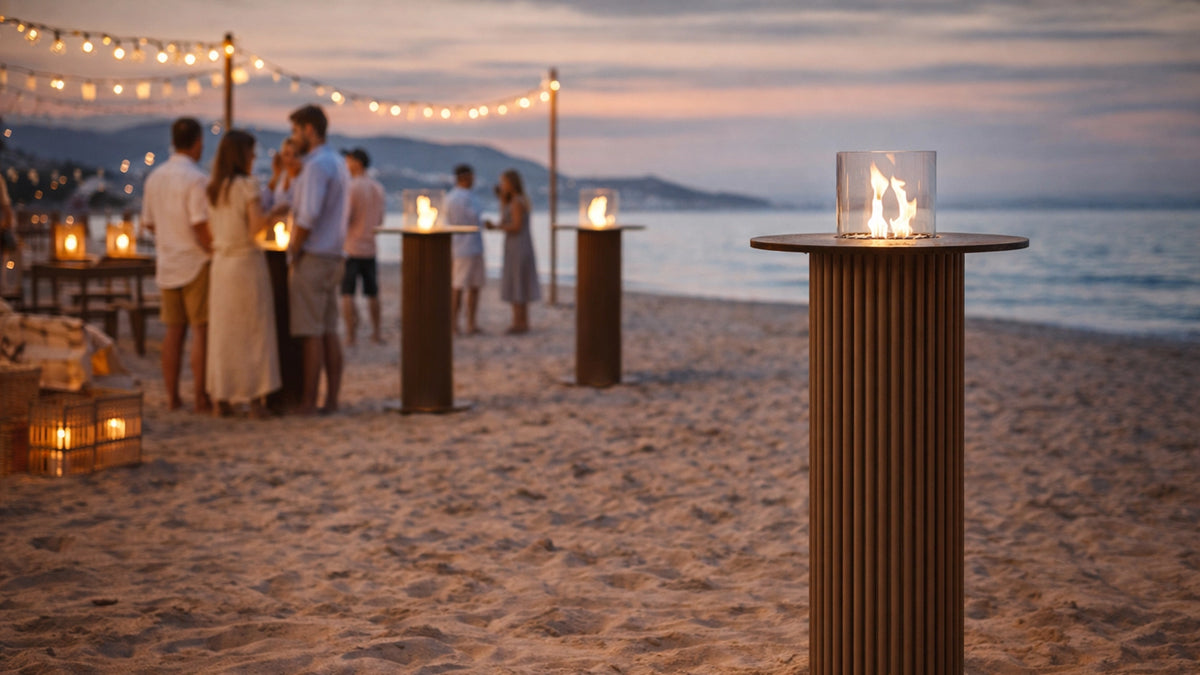 Bålstil Table Core tafelhaard met vlam op een sfeervol strandterras bij zonsondergang