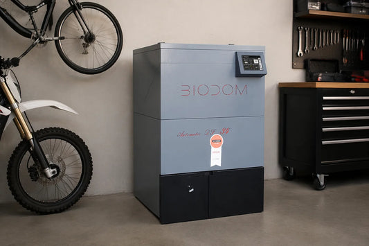 Biodom 27A pelletkachel in werkplaats, naast fiets en gereedschap