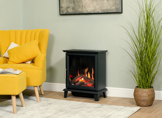 Charlton & Jenrick Luminosa Stove met vlammen in een woonkamer naast een gele fauteuil
