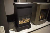 Calvix Sparky zwarte kachel met glazen deur en houtblokken, showroomopstelling