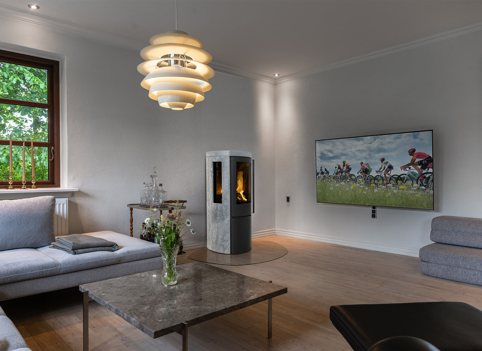 Jydepejsen Cozy Modern speksteenhaard in woonkamer met zijruiten en vlammen