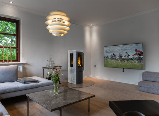Jydepejsen Cozy Modern speksteenhaard in woonkamer met zijruiten en vlammen