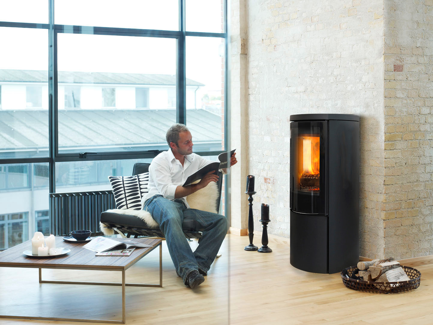 Jydepejsen Cozy Modern in woonkamer naast man met boek en brandend vuur