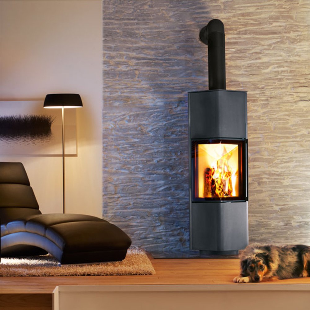 Spartherm Cubo L houtkachel in een moderne woonkamer met een ligstoel en een hond.