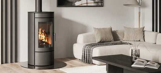 Nordic Fire Baldr CV houtkachel in lichte woonkamer naast bank