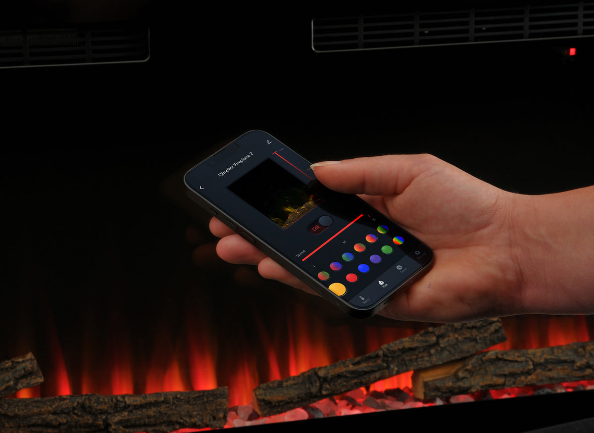 Dimplex Sense 50 bediend met smartphone-app boven elektrische haard met houtblokken en vlambeeld