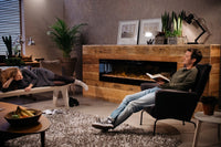 Dimplex Prism 74'' in moderne woonkamer met ingebouwde haard en zitende mensen