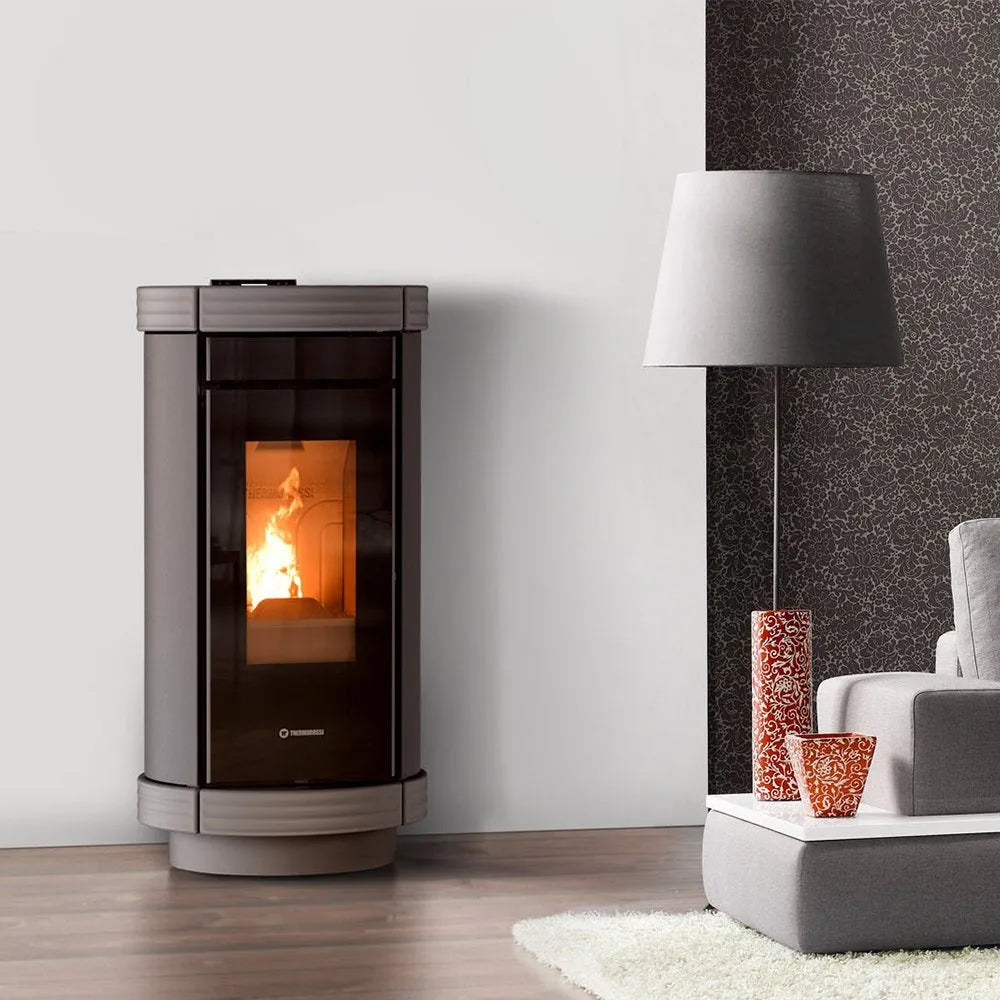 Thermorossi Dorica Plus Metalcolor pelletkachel in een moderne woonkamer met grijze en rode accenten.