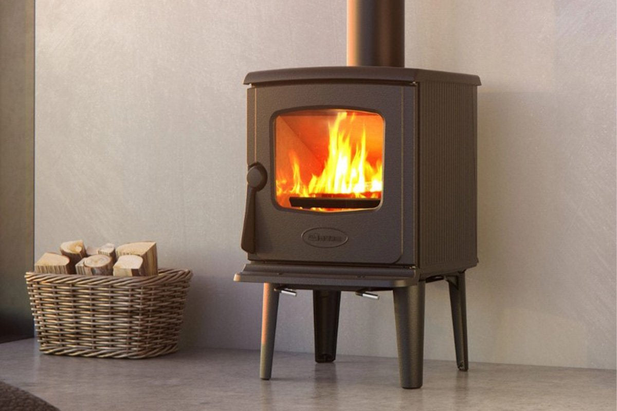 Dovre 325CB houtkachel met brandend vuur en houtmand ernaast