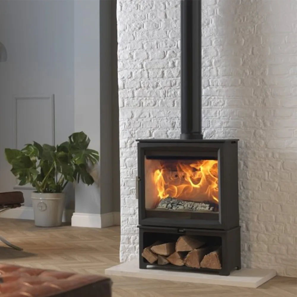 Charlton & Jenrick Fireline Woodtec 5 kW-XW extra breed 564 mm tegen witte bakstenen muur.