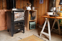 Charlton & Jenrick Go Eco Bake Chef in houten buitenkeuken met tafel en kookgerei