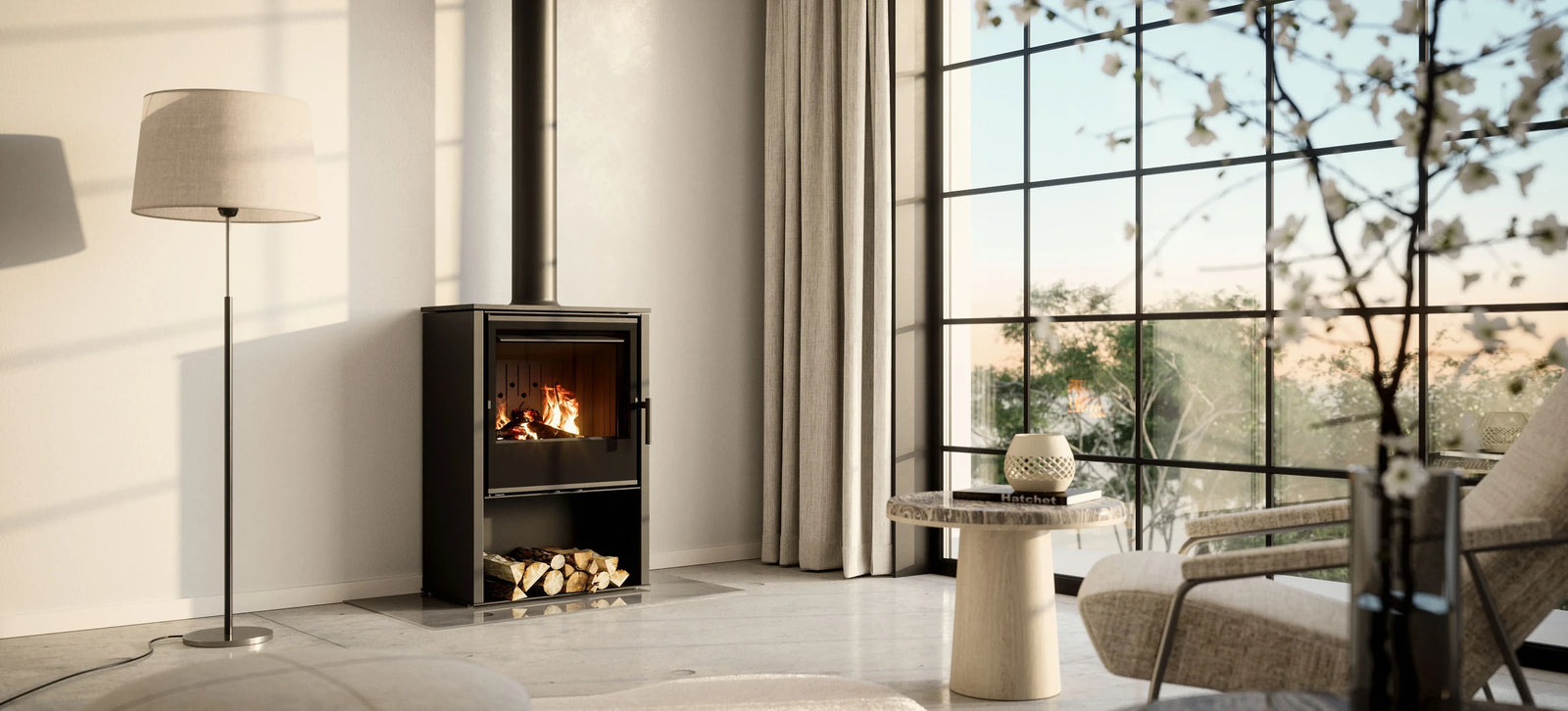 Nordic Fire Arden houtkachel in lichte woonkamer met grote ramen en bijzettafel