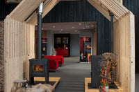 JAcobus 9 Doorkijk houtkachel in showroom met houten ombouw en brandend vuur
