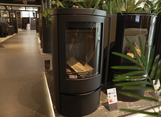 Jydepejsen Cozy Classic Low in showroom met planten en andere kachels