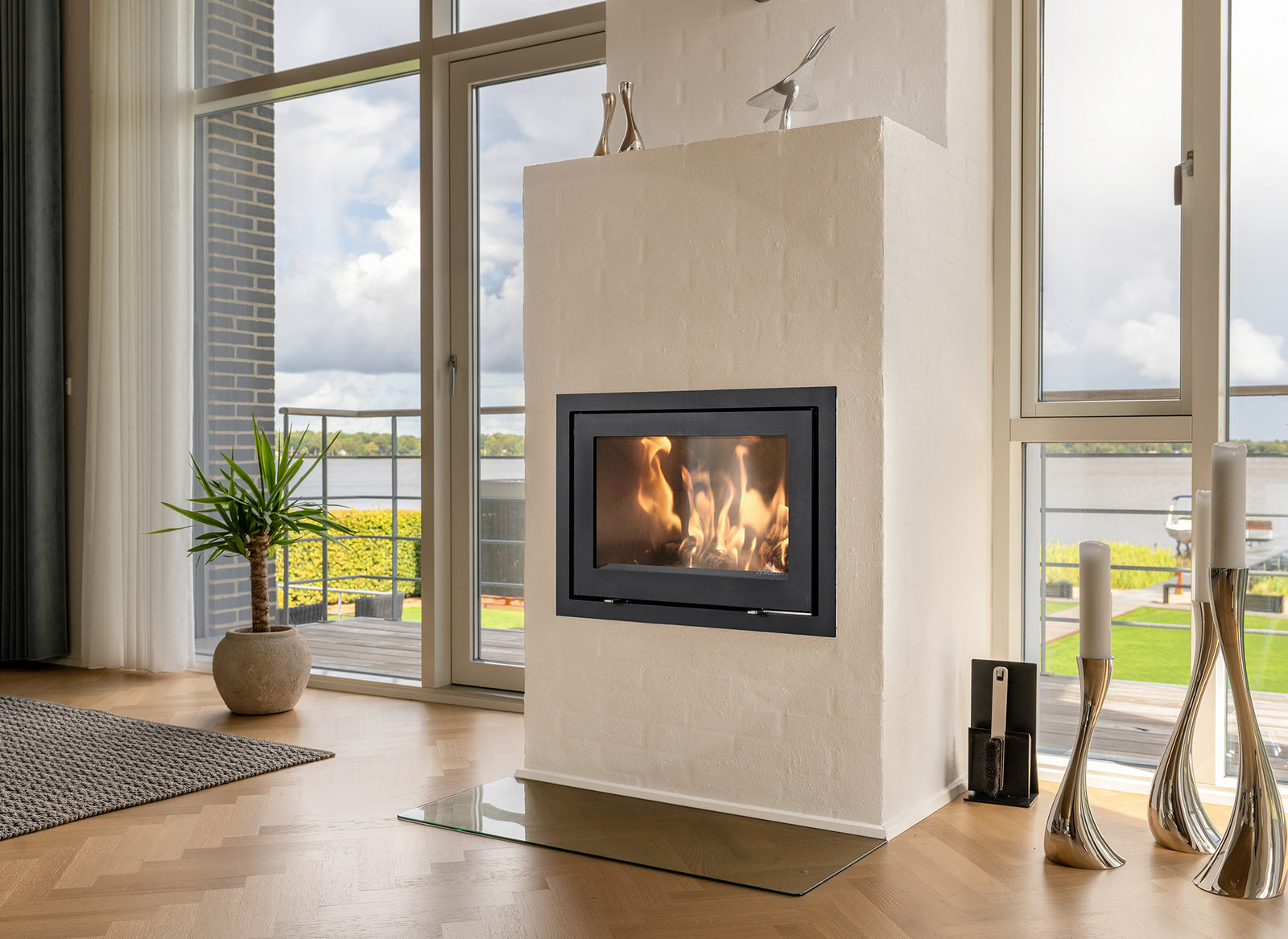 Jydepejsen H530 Classic haard in woonkamer met grote ramen en uitzicht op water