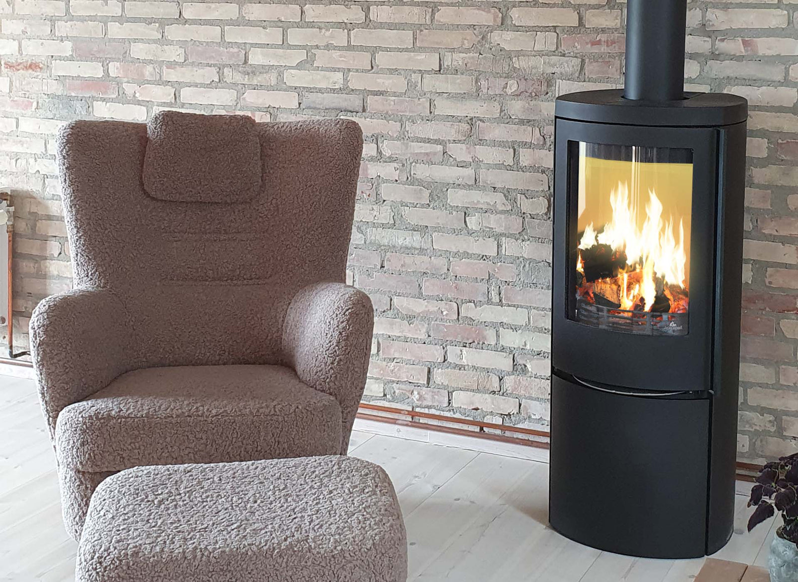 Jydepejsen Cozy Classic in woonkamer met brandend vuur naast fauteuil