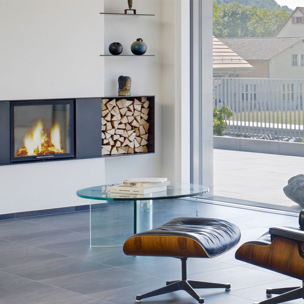 Spartherm Linear Front 67x57 in moderne woonkamer met brandend vuur en houtvak.