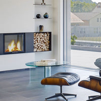 Spartherm Linear Front 67x57 in moderne woonkamer met brandend vuur en houtvak.
