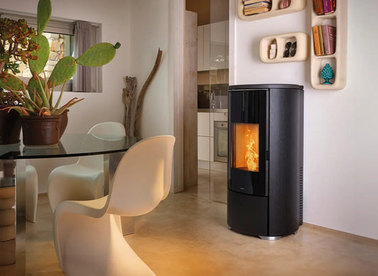 Nobis A8 Round Glass pelletkachel in moderne eetkamer, met vlammen zichtbaar