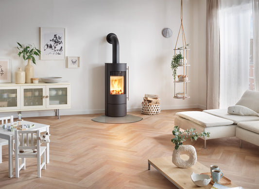 Olsberg Muna houtkachel in een lichte woonkamer met brandend vuur