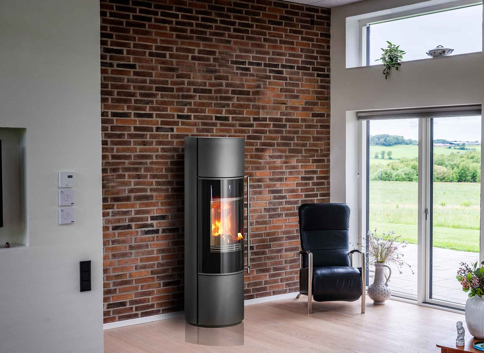 Jydepejsen Omega Core in woonkamer met brandend vuur naast bakstenen wand