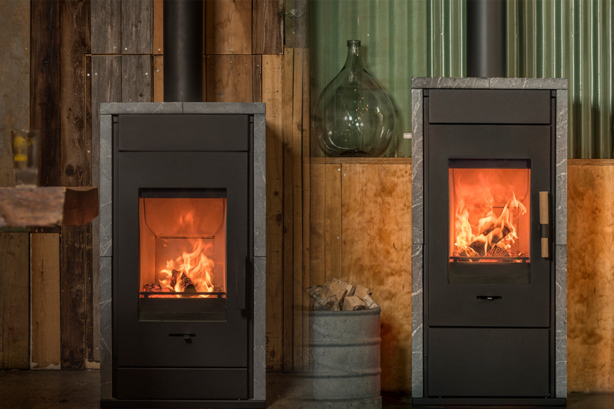 Wanders Pecan Eco Small speksteenkachel met brandend vuur in showroom