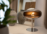 Cocoon Fires Pedestal (RVS) in moderne woonkamer met brandend vuur