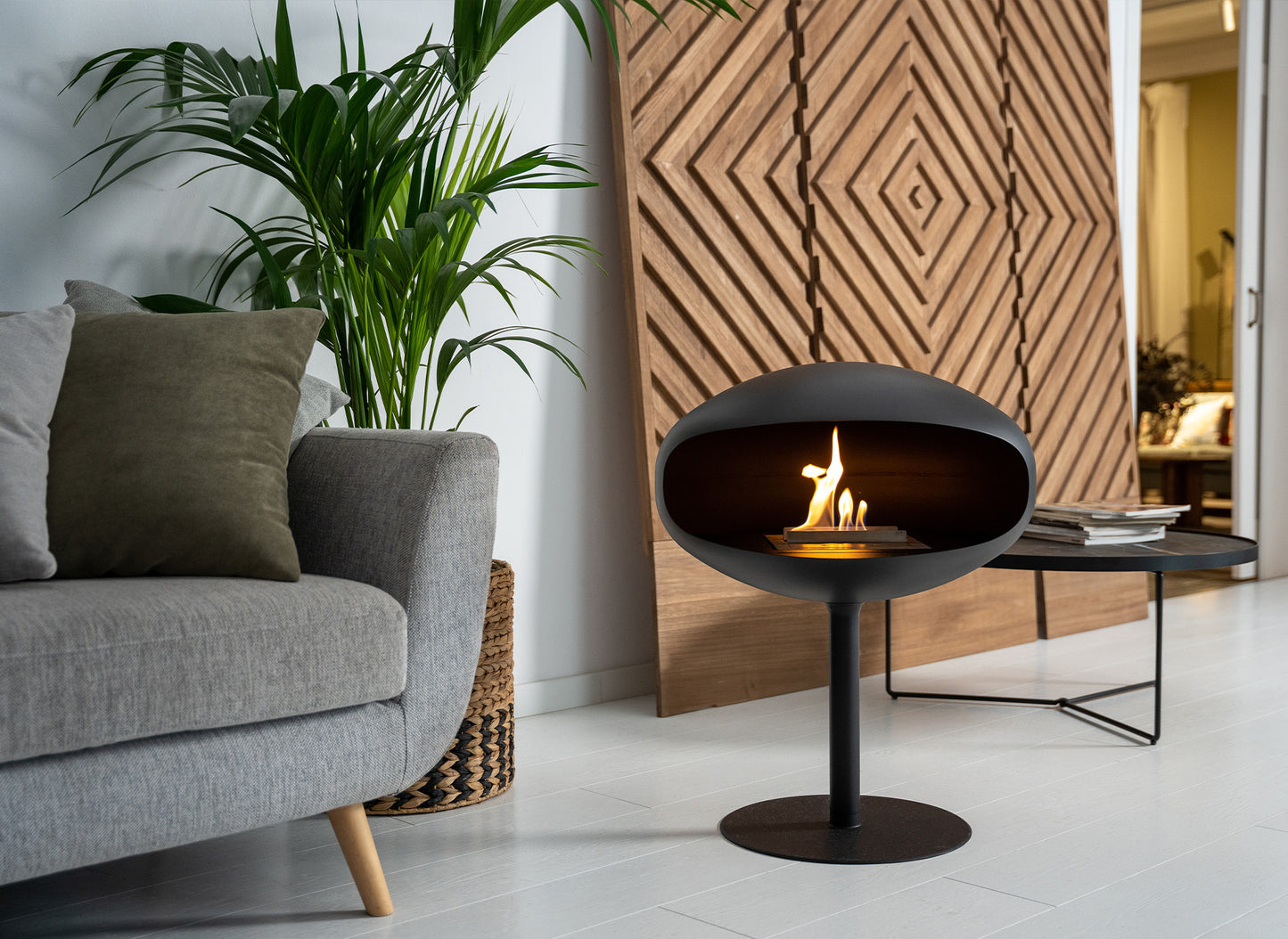 Cocoon Fires Pedestal zwart in moderne woonkamer met brandende vlam