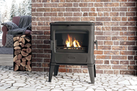 Dovre TAI45WD houtkachel met brandend vuur voor bakstenen muur