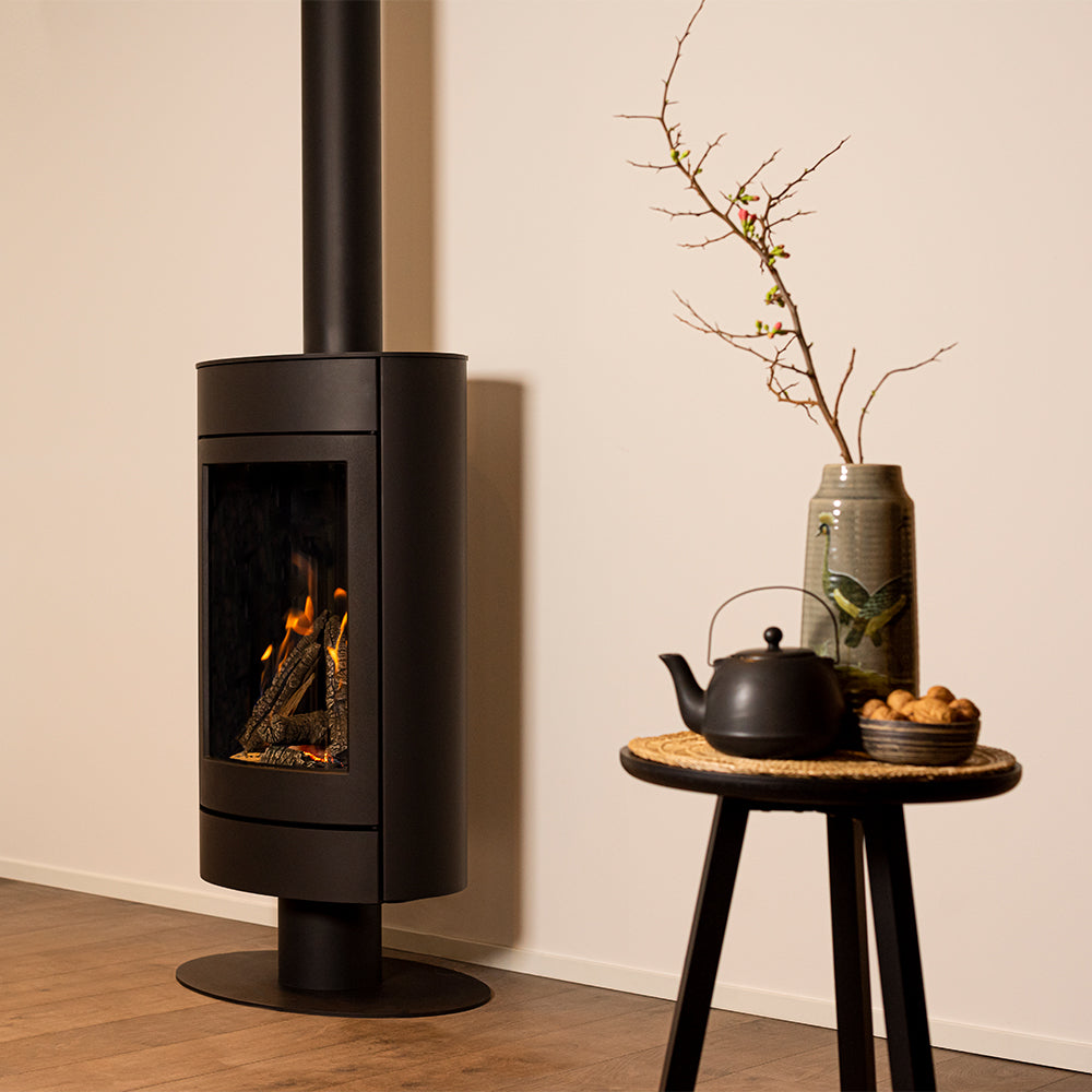 Wanders Tali Base Round gaskachel in woonkamer naast tafeltje met vaas en theepot