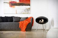 Cocoon Fires Terra zwart naast grijze bank in moderne woonkamer