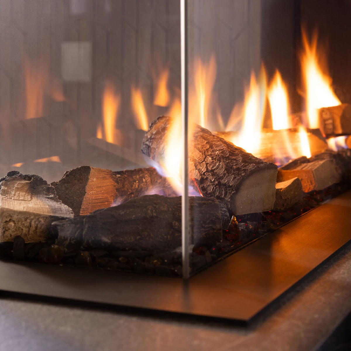 Trimline Fires 120 Room Divider met brandende houtblokken achter glazen hoekruit