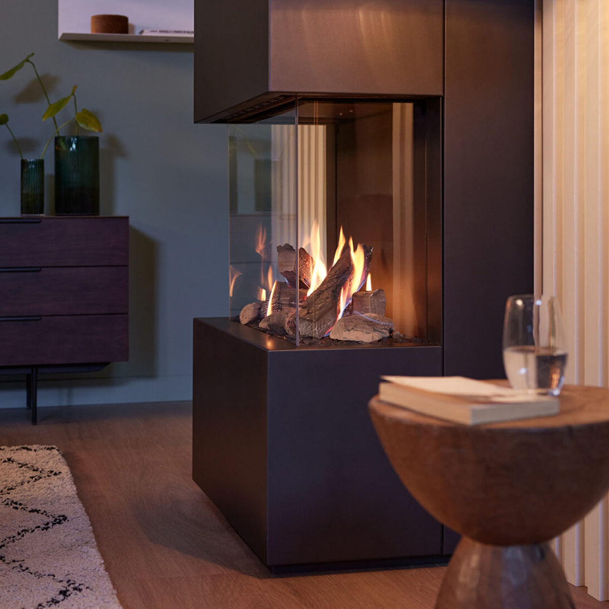 Trimline Fires Obsidian gashaard met brandende houtblokken in een modern interieur