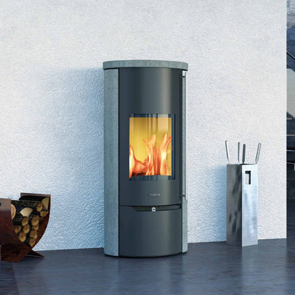 Olsberg Tolima PowerSystem II Compact, een moderne houtkachel met brandend vuur, in een strakke woonkamer.