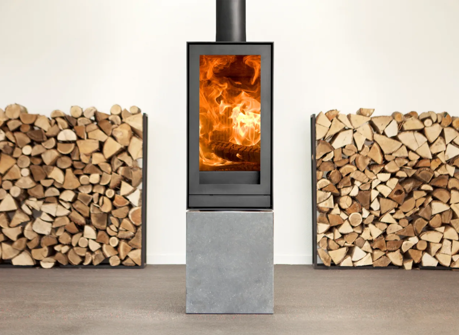 Nestor Martin TQH13 houtkachel met vuur, naast stapels haardhout