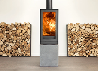 Nestor Martin TQH13 houtkachel met vuur, naast stapels haardhout