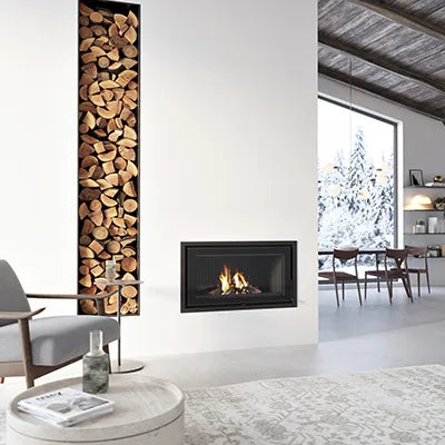 Dovre Vista 701I gietijzeren binnenwerk in moderne woonkamer met houtopslag en winterlandschap buiten.