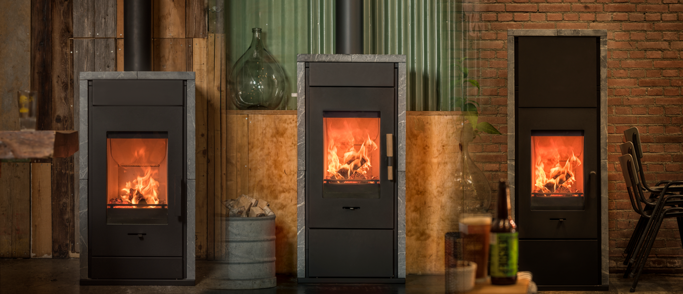 Wanders Pecan Eco Large speksteenkachel in industriële ruimte met drie brandende modellen