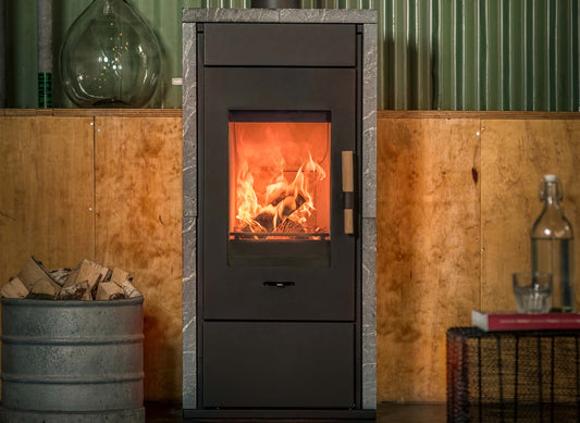 Wanders Pecan Eco Medium speksteenkachel met brandend vuur in een sfeervolle woonkamer