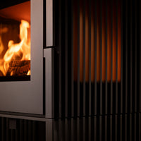 Close-up van Trimline Fires Woody Loft 3L met brandende vlammen achter verticale zwarte spijlen